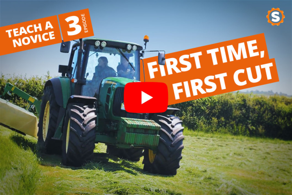Neuling lernt, wie man mit einem John Deere 6155 M mäht